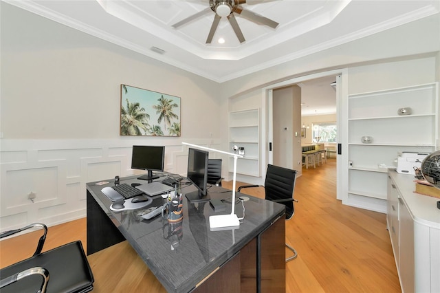 office with ceiling fan, crown molding, a raised ceiling, and light wood-type flooring