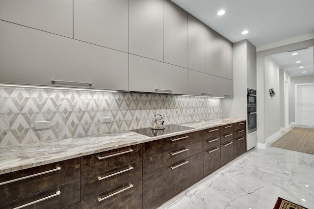 kitchen with light stone countertops, black electric stovetop, and tasteful backsplash