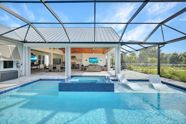 view of pool with an in ground hot tub, a patio area, glass enclosure, and ceiling fan