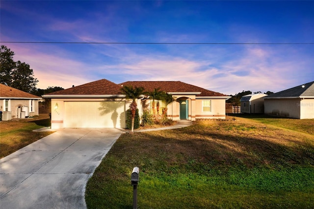 view of front of house with a garage and a lawn