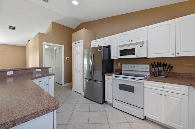 kitchen featuring white cabinetry, white appliances, light tile patterned floors, and vaulted ceiling