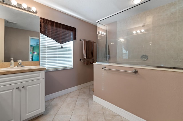 bathroom featuring vanity, tile patterned flooring, and a tile shower