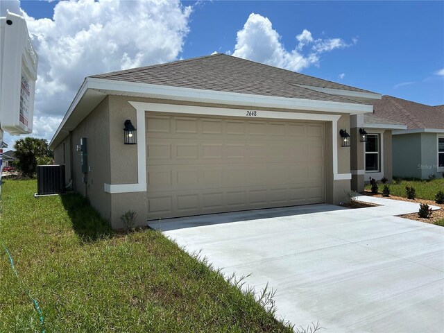 2648 Averland Loop, North Port, FL 34287 - view of front of home featuring stucco siding, a garage, driveway, a shingled roof, and a front lawn