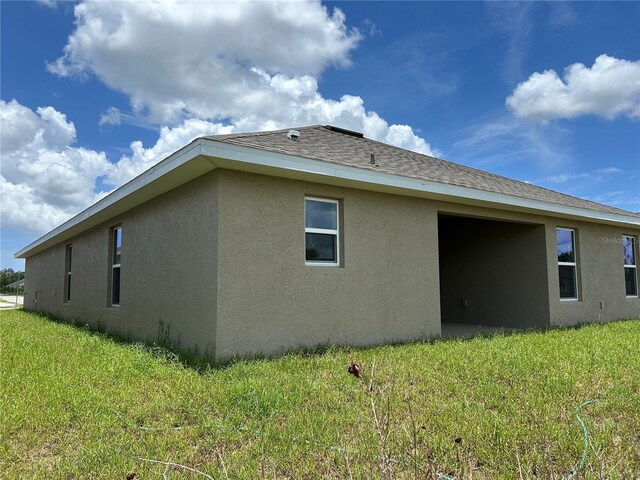 2648 Averland Loop, North Port, FL 34287 - view of property exterior with stucco siding, a lawn, and roof with shingles