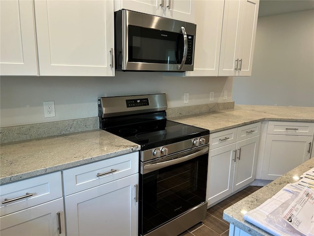 2648 Averland Loop, North Port, FL 34287 - kitchen with appliances with stainless steel finishes, white cabinets, wood tiled floors, and light stone countertops