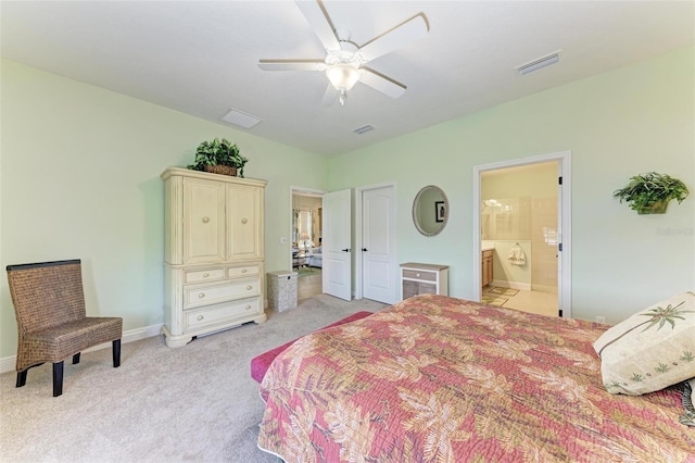 bedroom with ceiling fan, ensuite bathroom, and light carpet