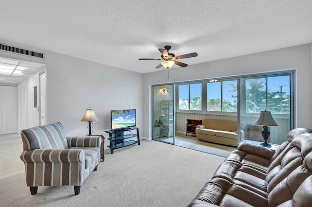 carpeted living room featuring a textured ceiling and ceiling fan