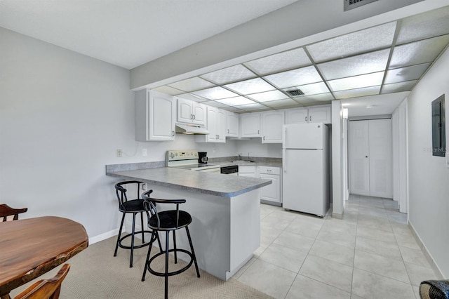 kitchen featuring white cabinets, kitchen peninsula, a kitchen breakfast bar, and white appliances