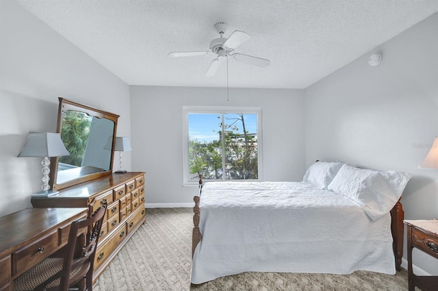 bedroom featuring ceiling fan, light carpet, and a textured ceiling