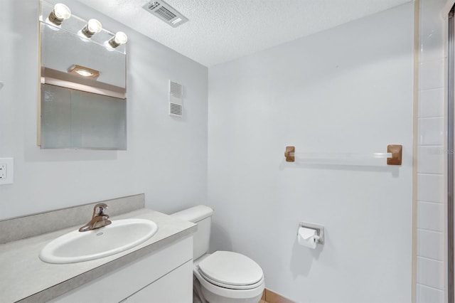 bathroom featuring a shower with shower door, a textured ceiling, toilet, and vanity