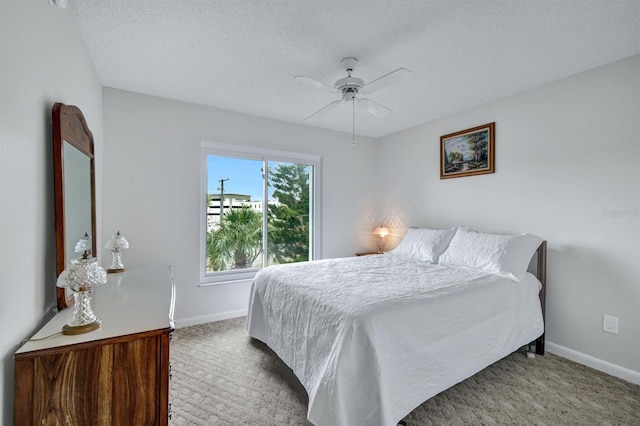 bedroom with ceiling fan, a textured ceiling, and carpet flooring