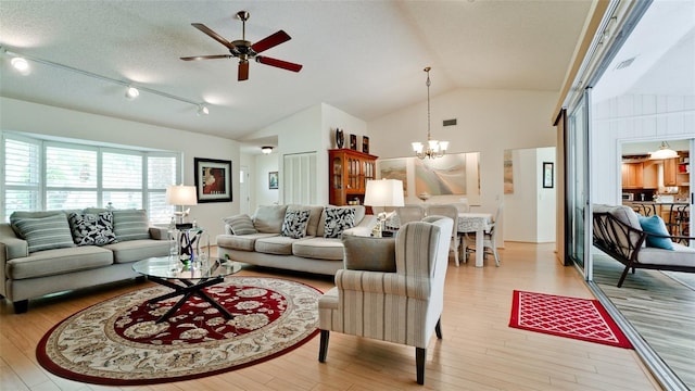 living room featuring light hardwood / wood-style floors, ceiling fan with notable chandelier, a textured ceiling, and vaulted ceiling