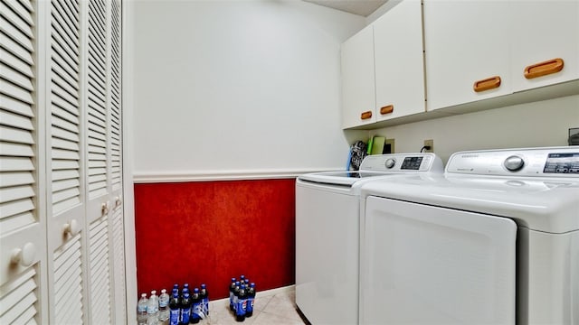 laundry area with cabinets, light tile patterned floors, and washing machine and clothes dryer