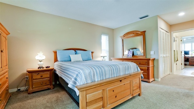 carpeted bedroom with a closet and multiple windows