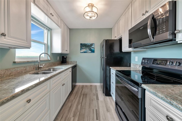 kitchen featuring sink, range with electric cooktop, black dishwasher, white cabinets, and light wood-type flooring