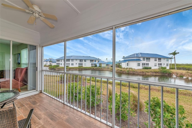 sunroom with a water view, plenty of natural light, and ceiling fan