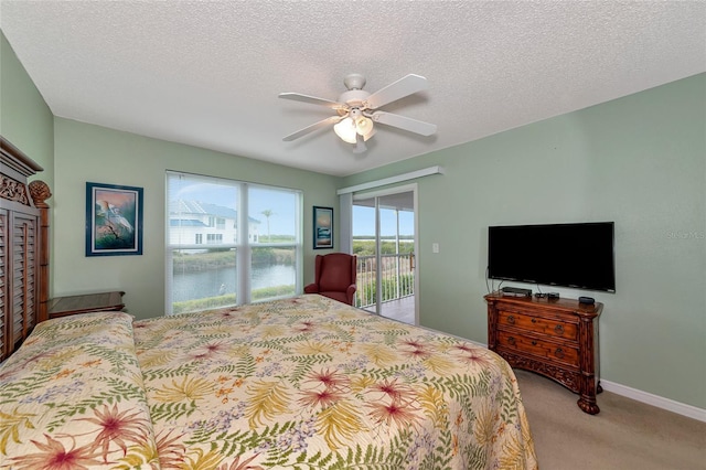 carpeted bedroom featuring access to outside, a textured ceiling, and ceiling fan