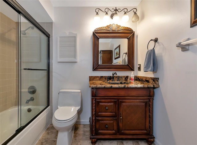 full bathroom featuring vanity, tile patterned flooring, combined bath / shower with glass door, and toilet