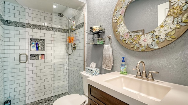 bathroom with toilet, a shower with shower door, and vanity