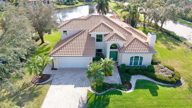 mediterranean / spanish-style home with a garage and a water view