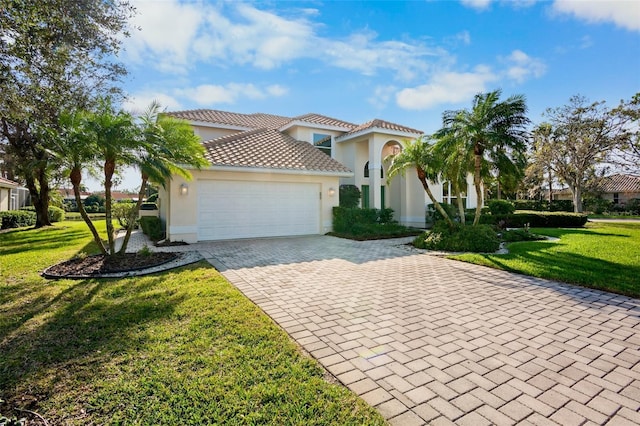 mediterranean / spanish-style house featuring a garage and a front yard