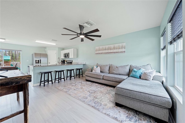 living room featuring ceiling fan and light hardwood / wood-style flooring