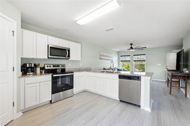 kitchen featuring white cabinetry, light hardwood / wood-style floors, kitchen peninsula, and stainless steel appliances