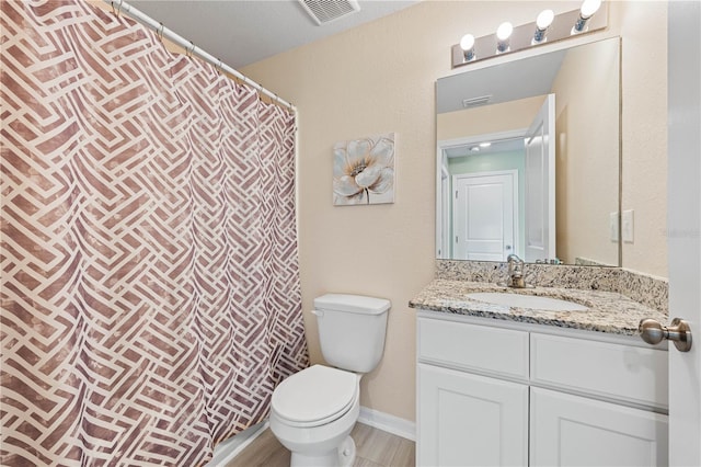 bathroom featuring vanity, toilet, and hardwood / wood-style floors