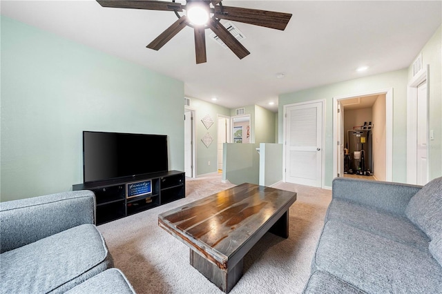 carpeted living room with ceiling fan and water heater