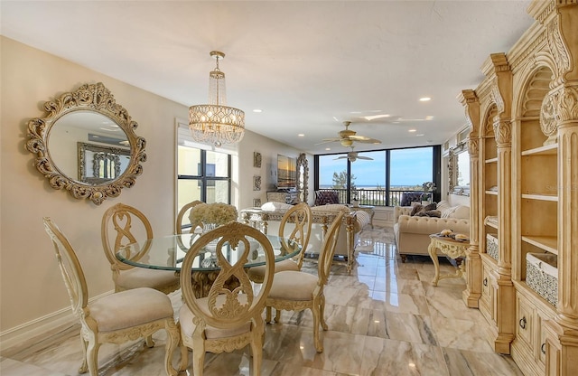 dining room featuring marble finish floor, expansive windows, a wealth of natural light, and ceiling fan with notable chandelier