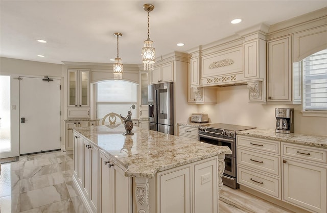 kitchen with appliances with stainless steel finishes, recessed lighting, cream cabinetry, and a center island