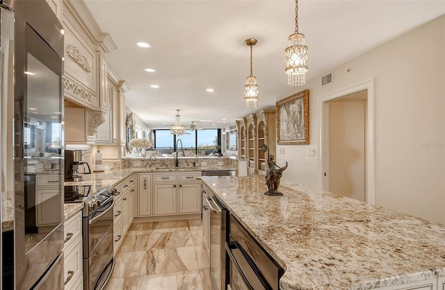 kitchen with recessed lighting, stainless steel appliances, a peninsula, visible vents, and cream cabinetry