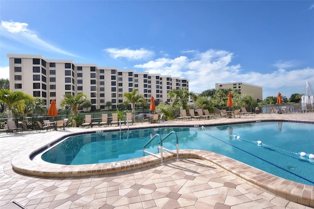 pool with a patio area and fence