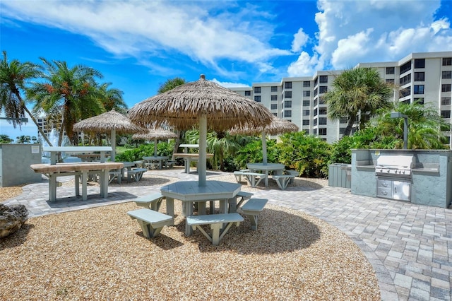 view of community with outdoor dining area, a patio area, and area for grilling