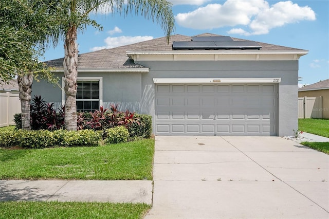 view of front of property featuring a garage, a front yard, and solar panels