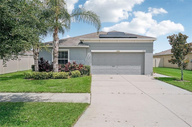 ranch-style house featuring a front yard, a garage, and solar panels