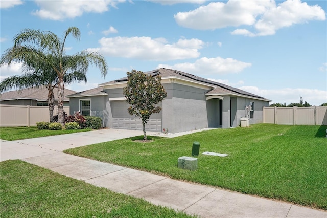 ranch-style home featuring a garage, a front lawn, and solar panels