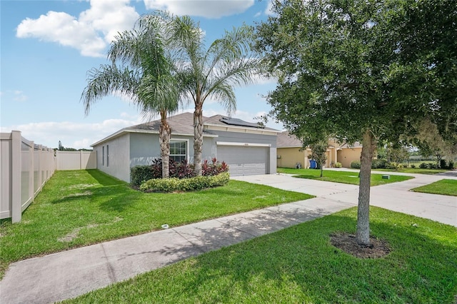 view of front of property with a front lawn, solar panels, and a garage