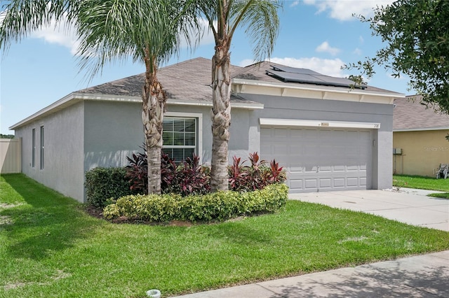 single story home with a garage, a front yard, and solar panels