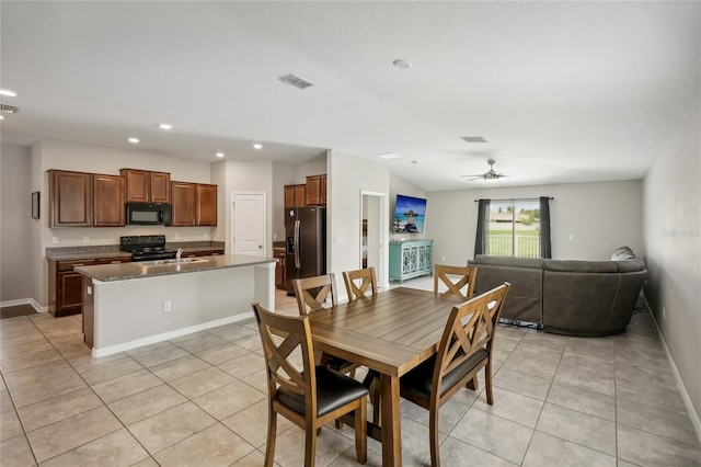 tiled dining area featuring ceiling fan and sink