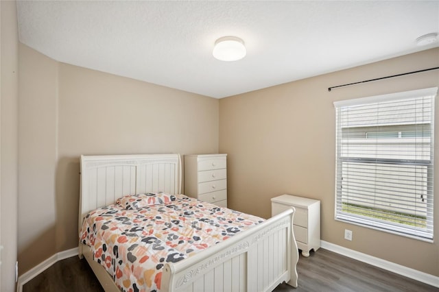 bedroom featuring dark hardwood / wood-style flooring and multiple windows