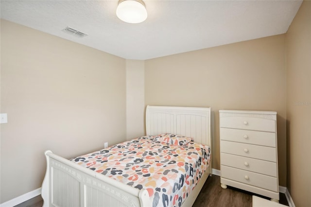 bedroom with dark hardwood / wood-style floors