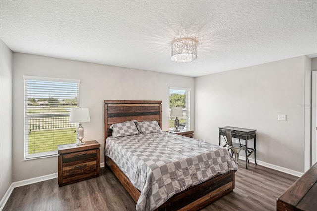 bedroom featuring a textured ceiling, an inviting chandelier, and dark hardwood / wood-style floors