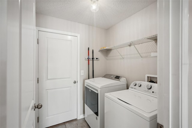 washroom featuring a textured ceiling and washer and clothes dryer