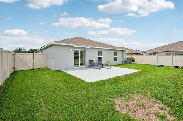 back of house with a lawn and a patio area