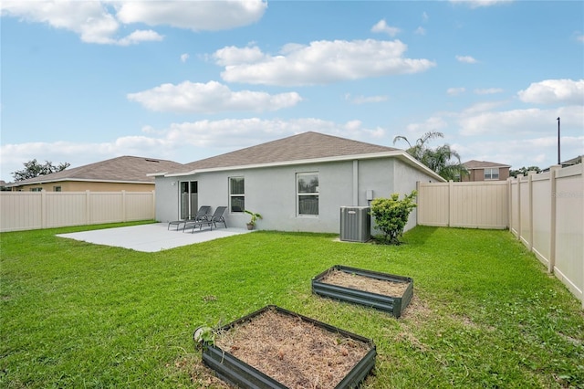 back of property with a patio area, a yard, and central AC