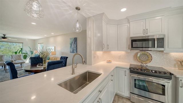 kitchen featuring pendant lighting, sink, white cabinets, and appliances with stainless steel finishes