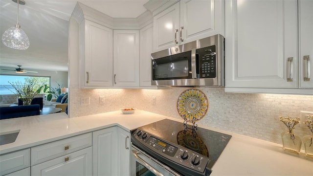 kitchen with ceiling fan, appliances with stainless steel finishes, white cabinetry, hanging light fixtures, and tasteful backsplash