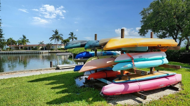 view of playground featuring a lawn, a boat dock, and a water view