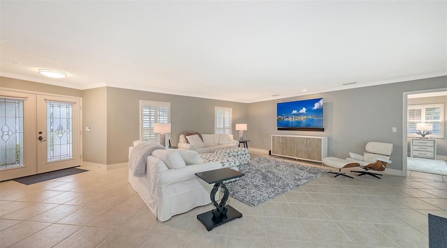 living room with a wealth of natural light, light tile patterned floors, crown molding, and french doors